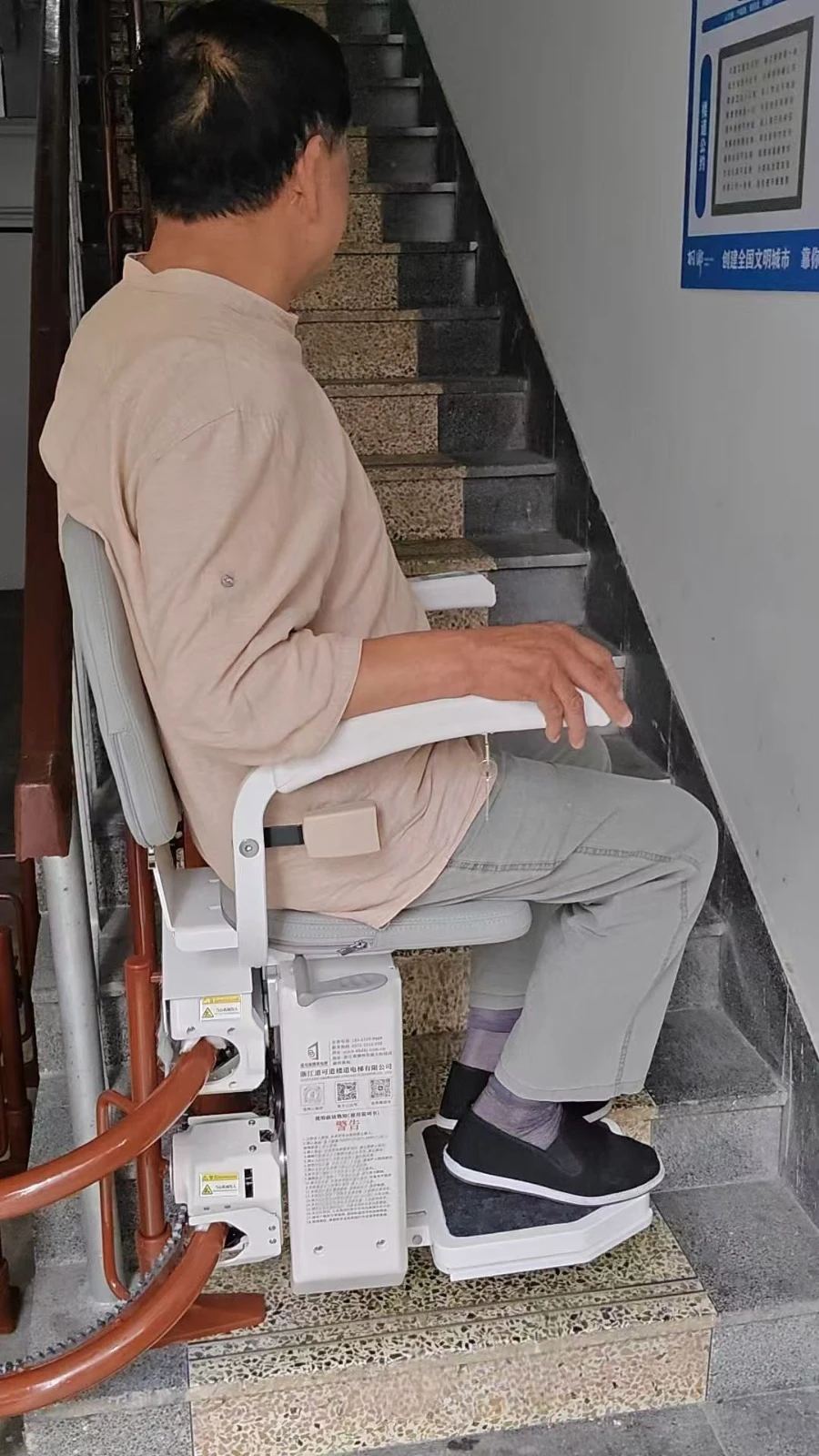 Man riding a stair chair lift installed by PK Elevator in Pakistan